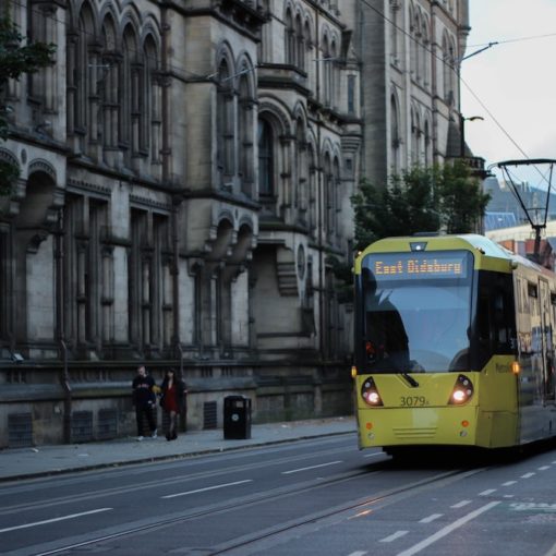 A tram travelling alongside Manchester Town Hall