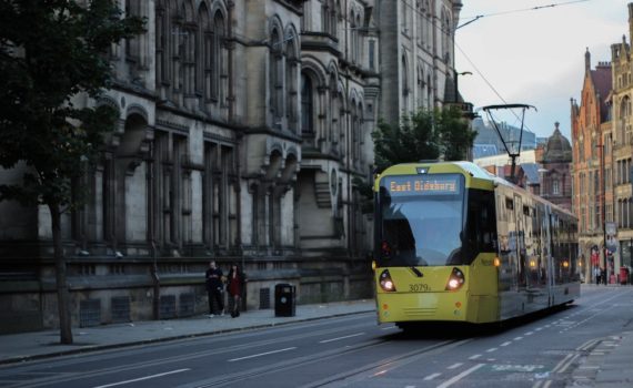 A tram travelling alongside Manchester Town Hall