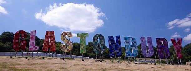 Giant Wording Sculpture spelling out GLASTONBURY in bright patchwork material.