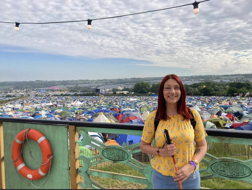 Photo of me at Glastonbury on sea with an ocean of tents behind me. Massive smile on my face as I have just been on live TV!