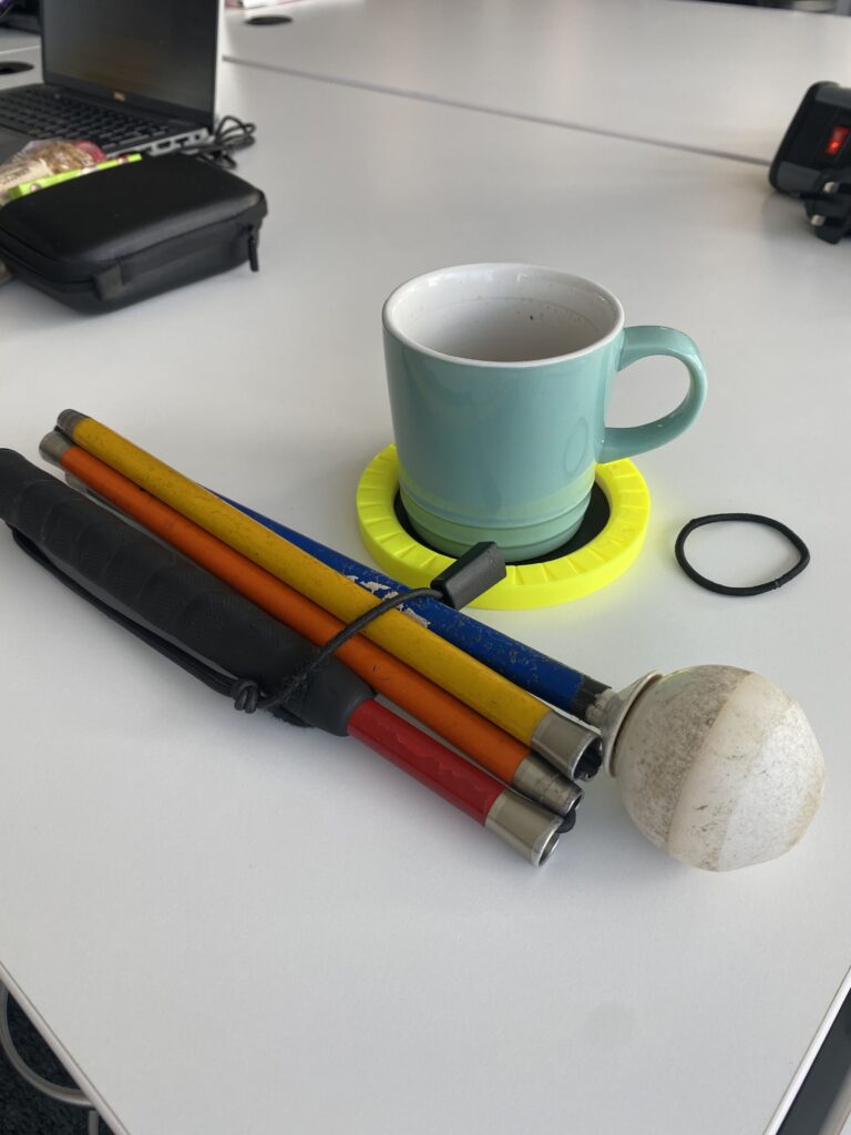 Photo of my cane, my coaster and a bobble on my work desk.