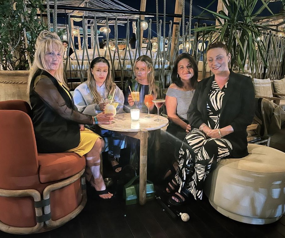 Picture of Nina and her Mum and Sisters sitting around a table having pre-dinner drinks.